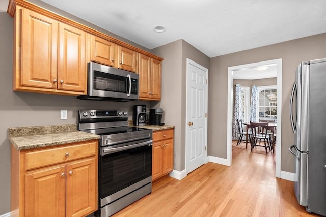 kitchen with light hardwood / wood-style flooring and appliances with stainless steel finishes