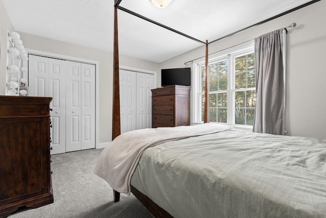 bedroom featuring carpet floors and two closets