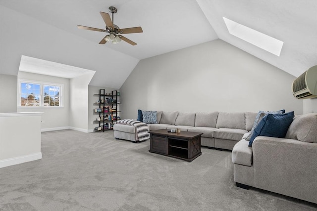 carpeted living room featuring ceiling fan, vaulted ceiling with skylight, and a wall mounted AC