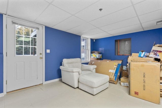 living area with a drop ceiling