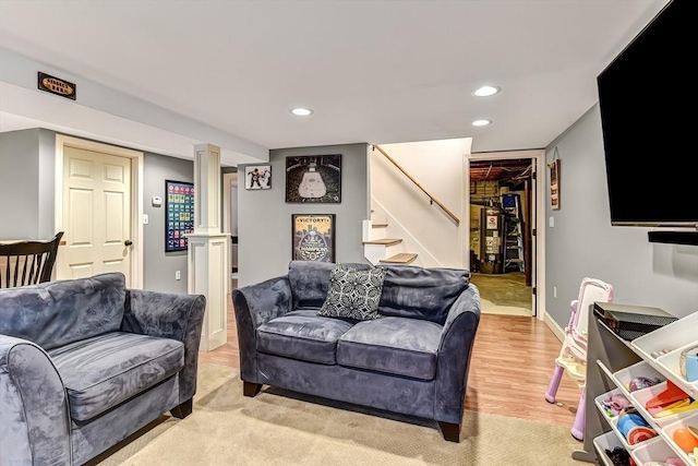 living area with recessed lighting, baseboards, stairway, light wood-type flooring, and ornate columns