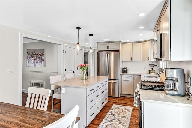 kitchen with a breakfast bar area, a sink, appliances with stainless steel finishes, a center island, and dark wood finished floors