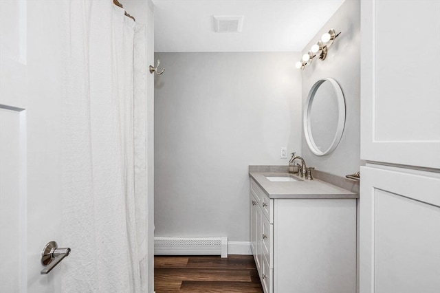 7 Washington St, Groveland, MA 01834 - full bathroom with vanity, wood finished floors, and a baseboard heating unit