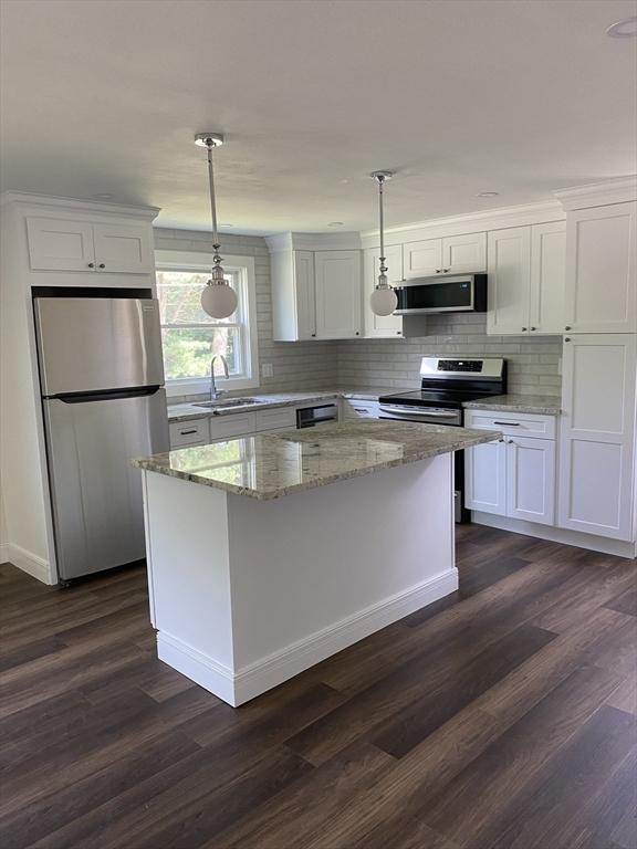 7 Washington St, Groveland, MA 01834 - kitchen with stainless steel appliances, white cabinetry, and dark wood-style flooring
