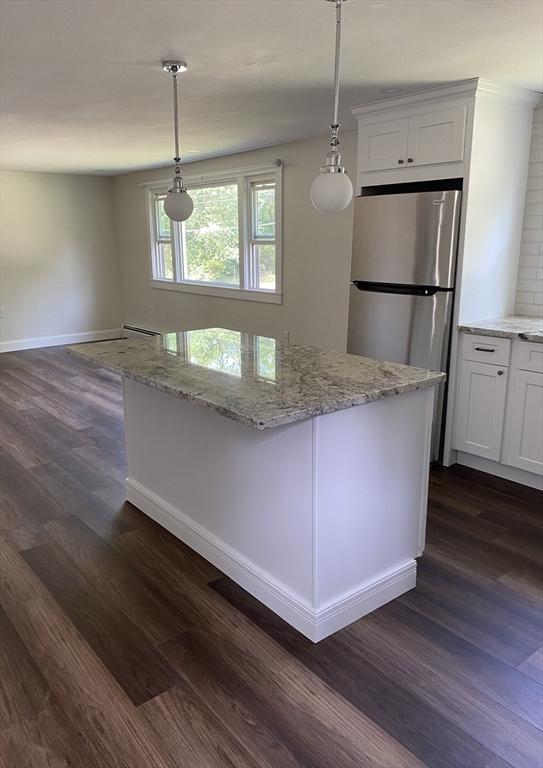 7 Washington St, Groveland, MA 01834 - kitchen with dark wood-style flooring, freestanding refrigerator, light stone countertops, and hanging light fixtures