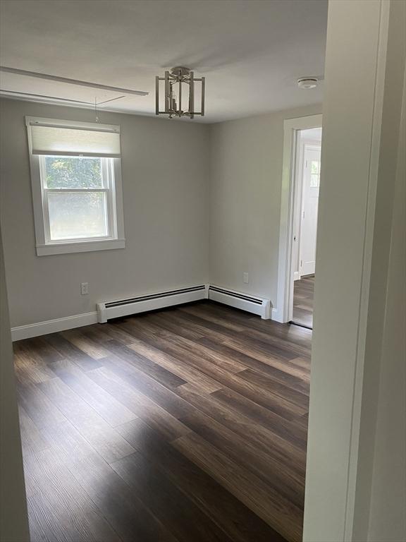 7 Washington St, Groveland, MA 01834 - empty room with dark wood-type flooring, baseboard heating, and a smoke detector