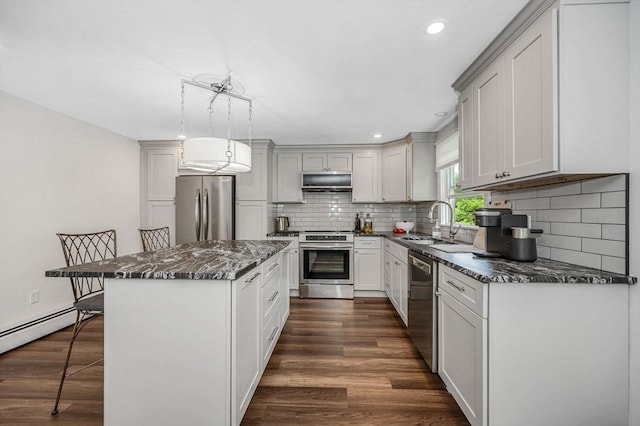 7 Washington St, Groveland, MA 01834 - kitchen with stainless steel appliances, a breakfast bar area, a kitchen island, dark stone countertops, and backsplash