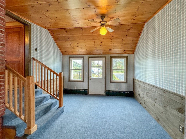 interior space featuring wood ceiling, vaulted ceiling, a healthy amount of sunlight, and carpet