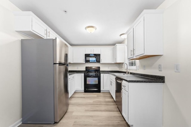 14 Watson St Unit 14, Lowell, MA 01852 - kitchen with black appliances, light wood-style floors, dark countertops, and white cabinets