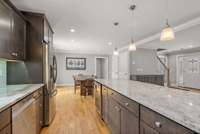 kitchen with stainless steel appliances, light stone countertops, dark brown cabinets, and decorative light fixtures