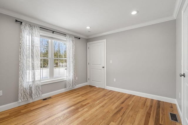 spare room with crown molding and light hardwood / wood-style floors