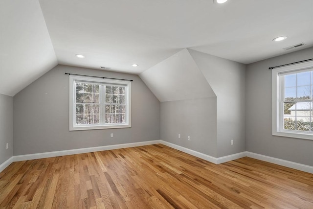 bonus room with vaulted ceiling and light hardwood / wood-style flooring