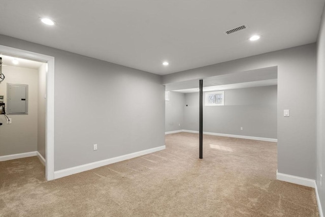 basement featuring light colored carpet and electric panel