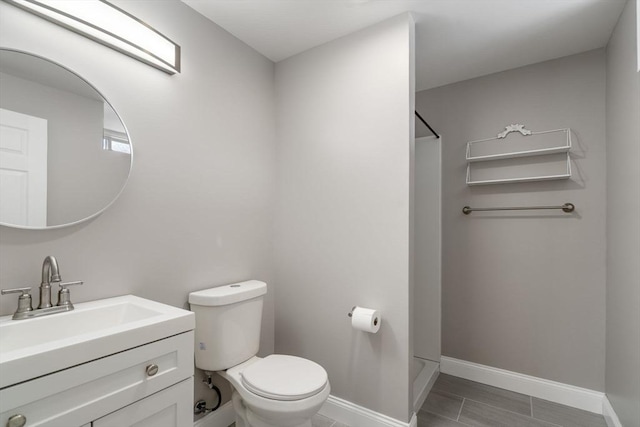 bathroom featuring vanity, toilet, and a shower