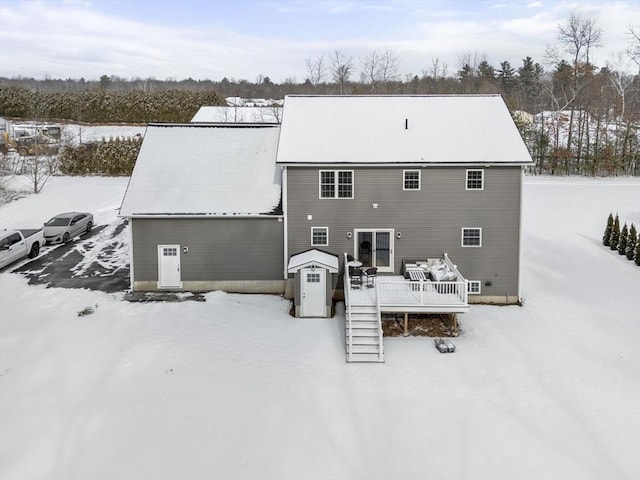 snow covered rear of property featuring a wooden deck