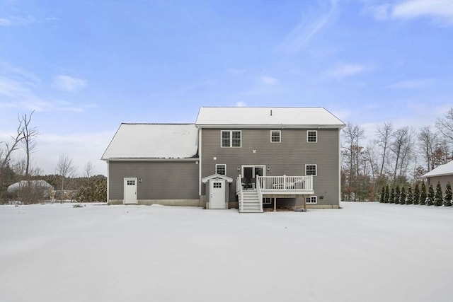 snow covered back of property featuring a wooden deck