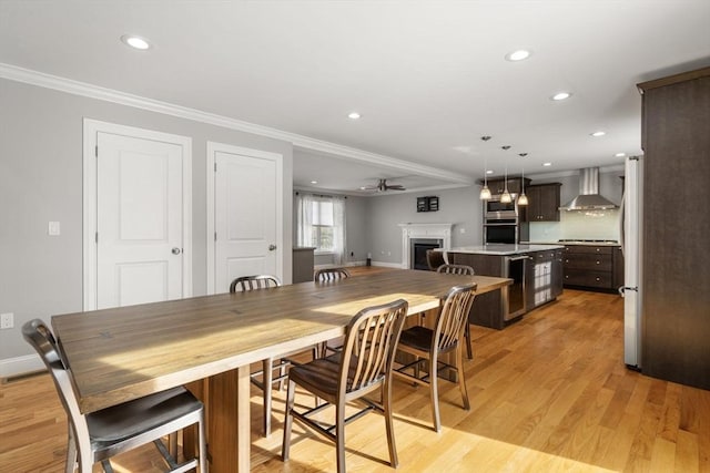 dining area with ceiling fan, ornamental molding, beverage cooler, and light hardwood / wood-style floors