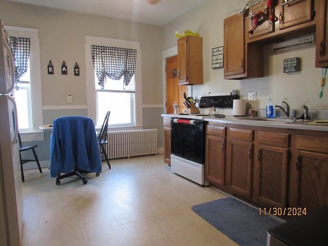 kitchen featuring sink, white appliances, and radiator