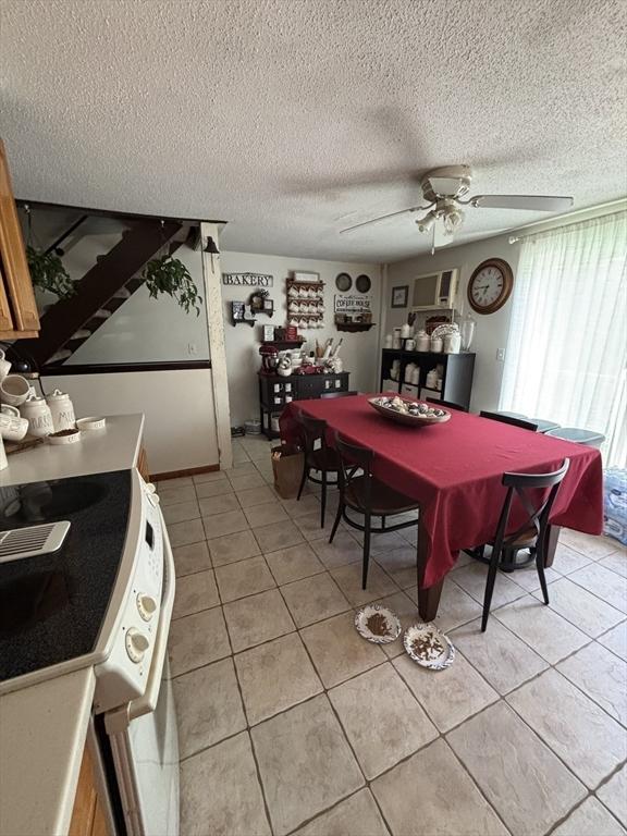 115 Redemption Rock Trl, Sterling, MA 01564 - dining space featuring ceiling fan, light tile patterned floors, a textured ceiling, and stairs