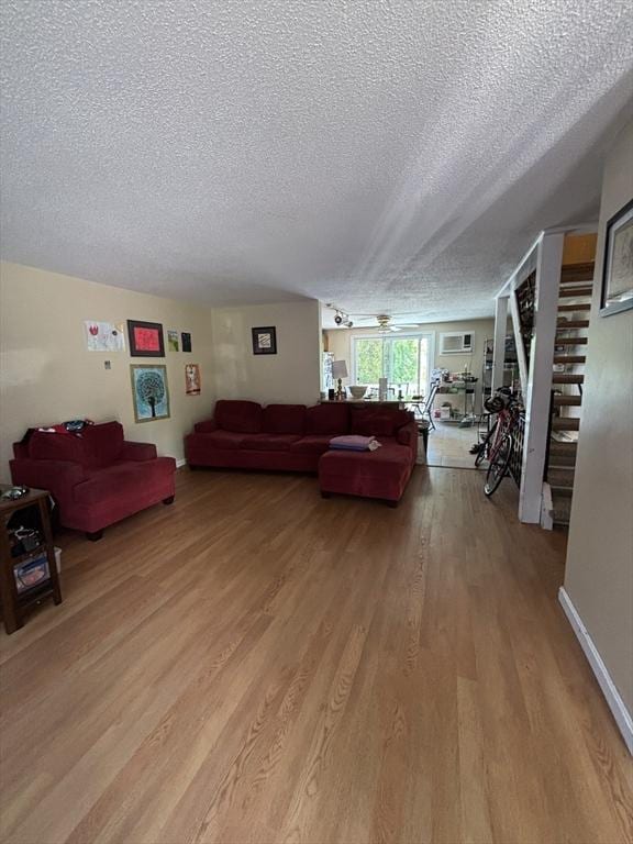 115 Redemption Rock Trl, Sterling, MA 01564 - living room featuring a textured ceiling, light wood-style flooring, and stairs