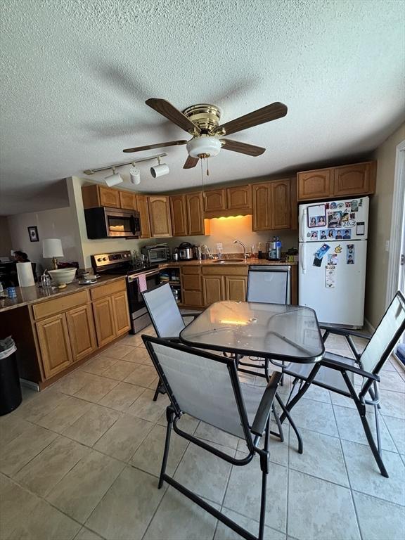 115 Redemption Rock Trl, Sterling, MA 01564 - kitchen featuring appliances with stainless steel finishes, a sink, ceiling fan, light tile patterned flooring, and a textured ceiling