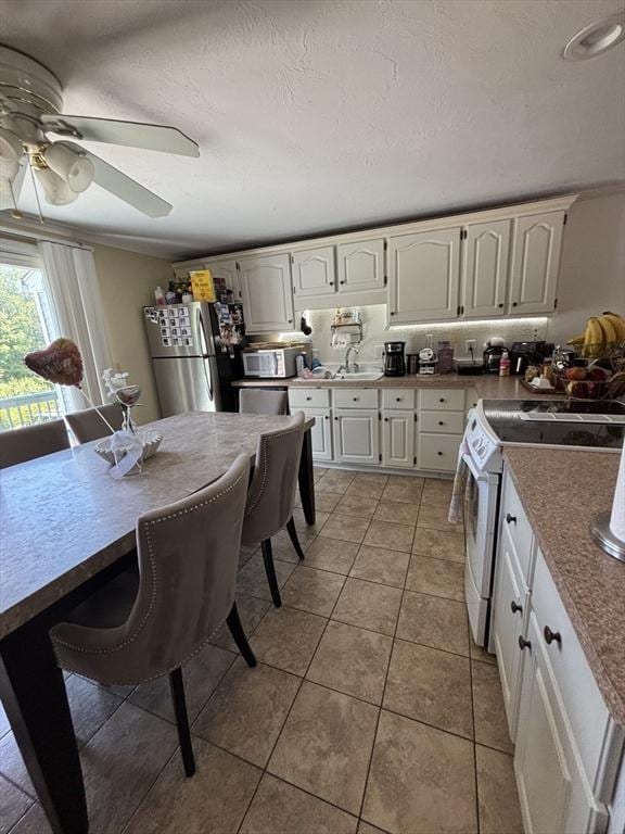 115 Redemption Rock Trl, Sterling, MA 01564 - kitchen featuring appliances with stainless steel finishes, light tile patterned floors, ceiling fan, a sink, and white cabinets