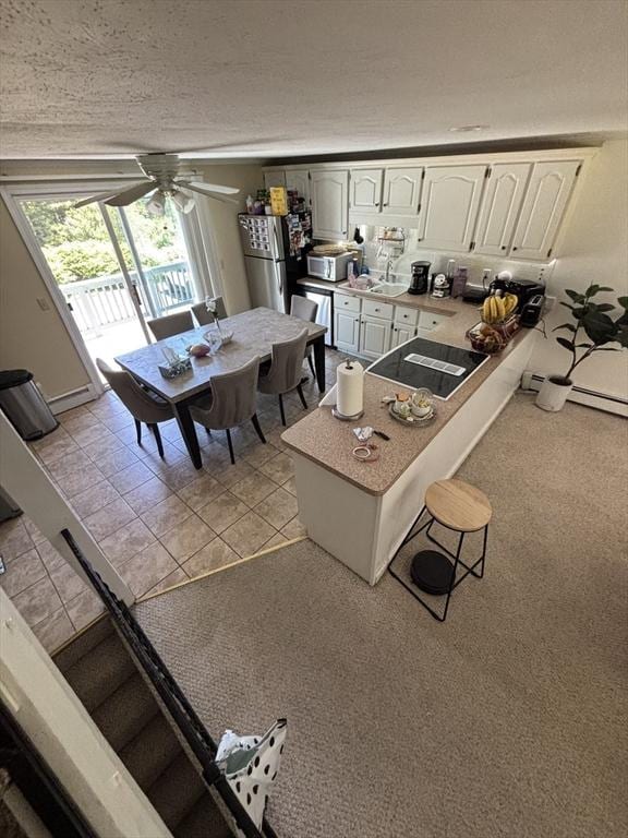 115 Redemption Rock Trl, Sterling, MA 01564 - kitchen featuring a peninsula, appliances with stainless steel finishes, ceiling fan, white cabinets, and light colored carpet