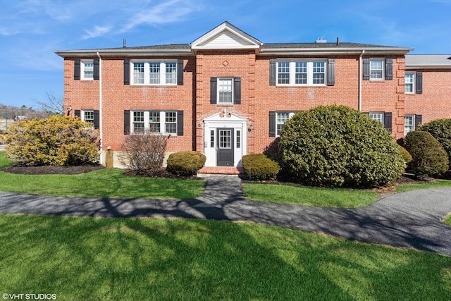 view of front of property with a front yard and brick siding