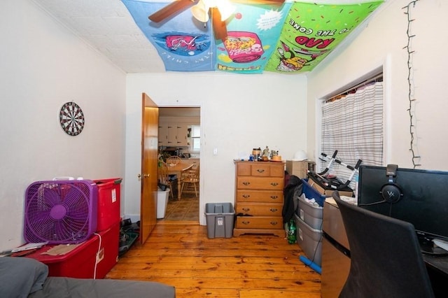 bedroom featuring wood-type flooring, a desk, and ceiling fan
