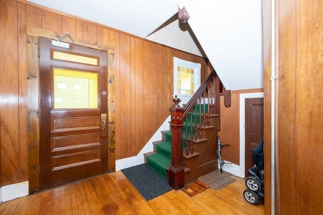 staircase featuring wood-type flooring and wooden walls