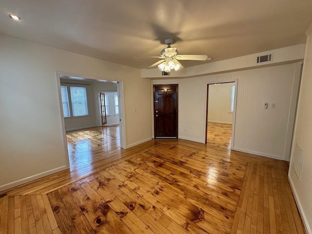 empty room featuring hardwood / wood-style floors, ceiling fan, and baseboards