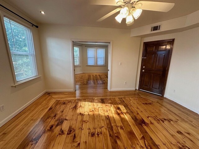 spare room with hardwood / wood-style flooring, ceiling fan, and baseboards