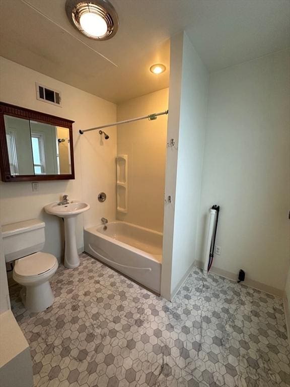 bathroom featuring toilet, bathtub / shower combination, tile patterned flooring, baseboards, and a sink