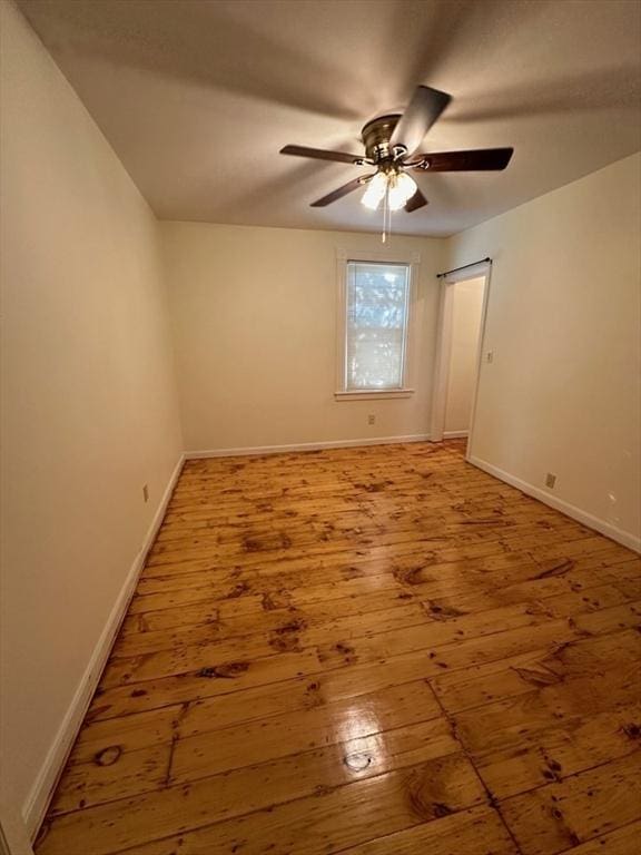 unfurnished room with wood-type flooring, ceiling fan, and baseboards