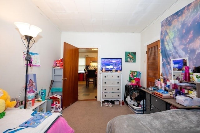 bedroom featuring carpet flooring, a closet, and crown molding