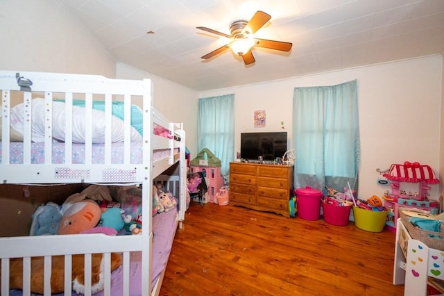 bedroom featuring wood finished floors, ornamental molding, and ceiling fan