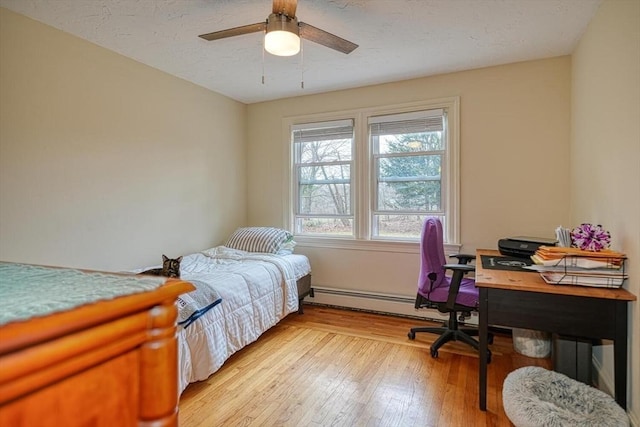 bedroom with a baseboard radiator, light wood-type flooring, and a ceiling fan