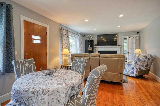 dining space with recessed lighting, wood finished floors, a fireplace, and baseboards