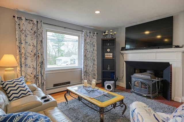living room with a baseboard heating unit, a wood stove, and recessed lighting