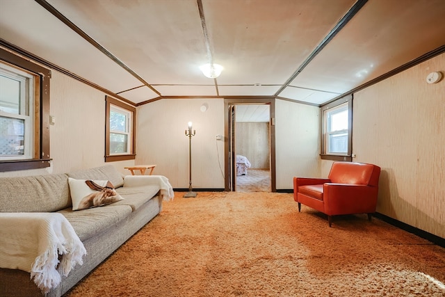 living room featuring lofted ceiling, carpet floors, wooden walls, and ornamental molding