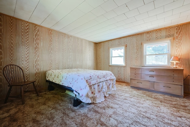 carpeted bedroom with wooden walls