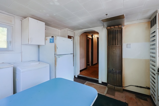 kitchen featuring white refrigerator, white cabinetry, and washer and clothes dryer