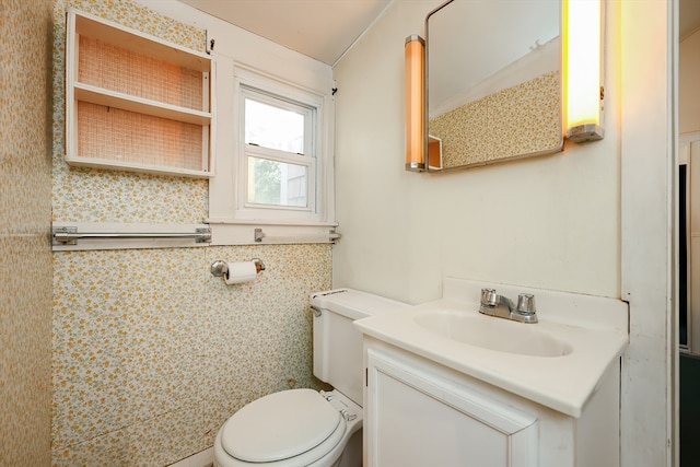 bathroom featuring vanity, toilet, and tile walls