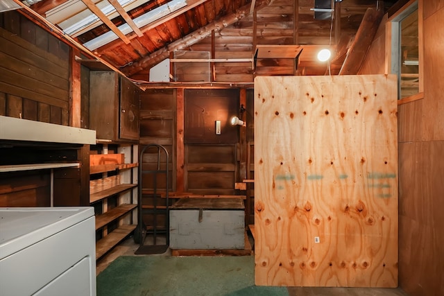 basement featuring wooden walls and washer / clothes dryer