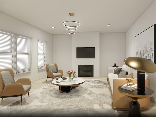 living area featuring a glass covered fireplace, baseboards, and recessed lighting