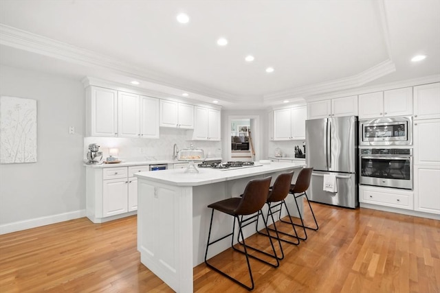 12 Scotland Dr, Andover, MA 01810 - kitchen featuring appliances with stainless steel finishes, recessed lighting, light countertops, white cabinetry, and a kitchen breakfast bar