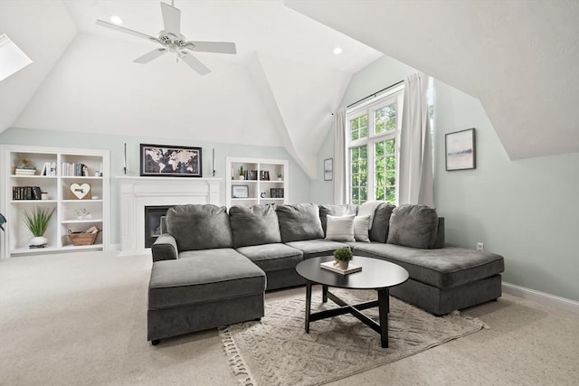 12 Scotland Dr, Andover, MA 01810 - carpeted living room with vaulted ceiling, built in shelves, a fireplace with flush hearth, ceiling fan, and baseboards