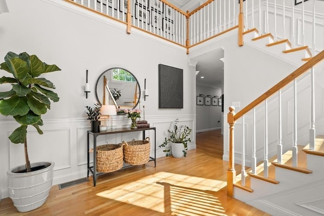 12 Scotland Dr, Andover, MA 01810 - foyer featuring stairs, wood finished floors, a wainscoted wall, a high ceiling, and a decorative wall