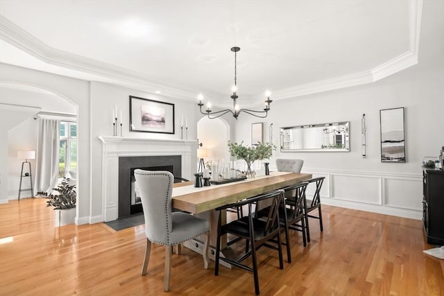 12 Scotland Dr, Andover, MA 01810 - dining space featuring arched walkways, a fireplace with flush hearth, a chandelier, crown molding, and light wood-style floors