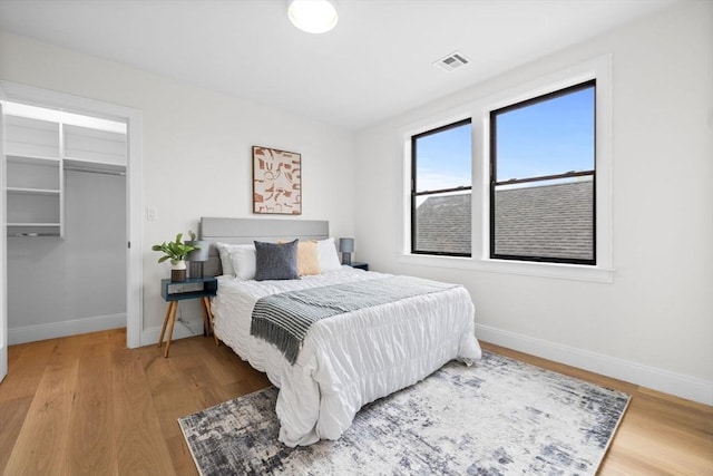 42 Bower St Unit 2, Medford, MA 02155 - bedroom featuring baseboards, wood finished floors, and a walk in closet